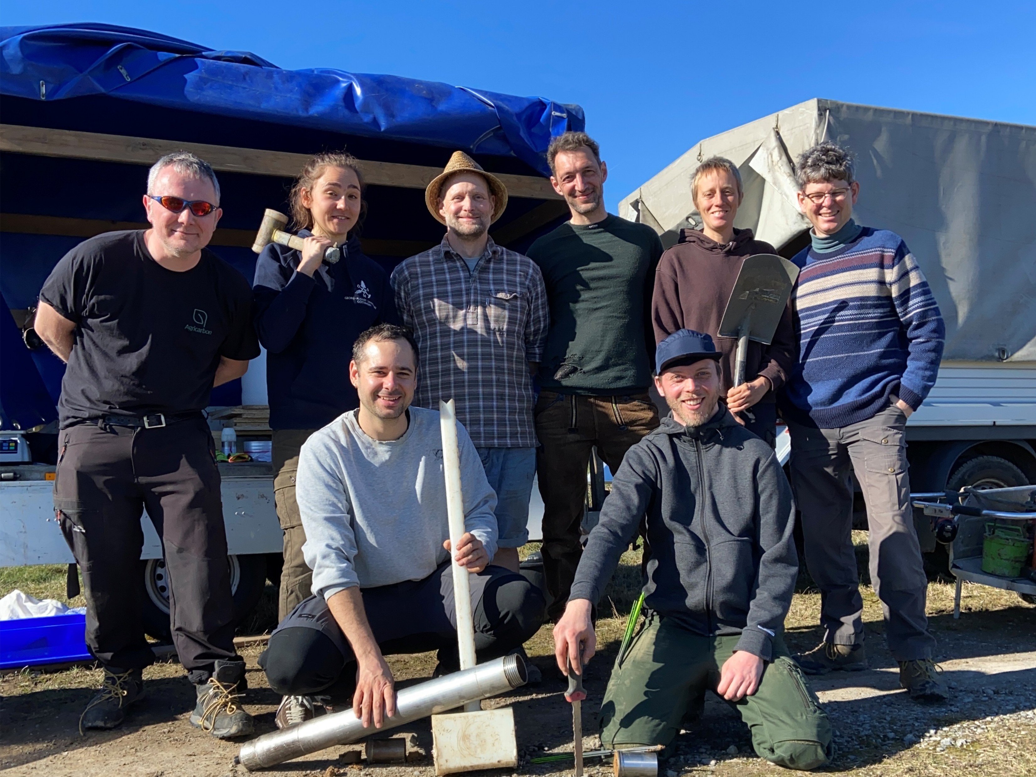 Group of researchers posing with soil sampling equipment.