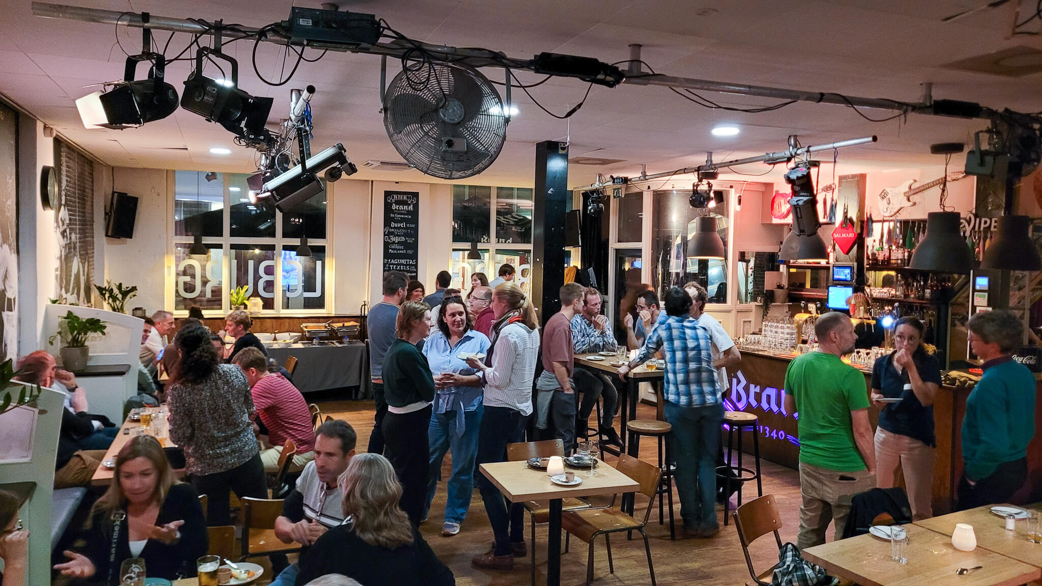 A lively restaurant scene with patrons eating and drinking, creating a vibrant atmosphere.